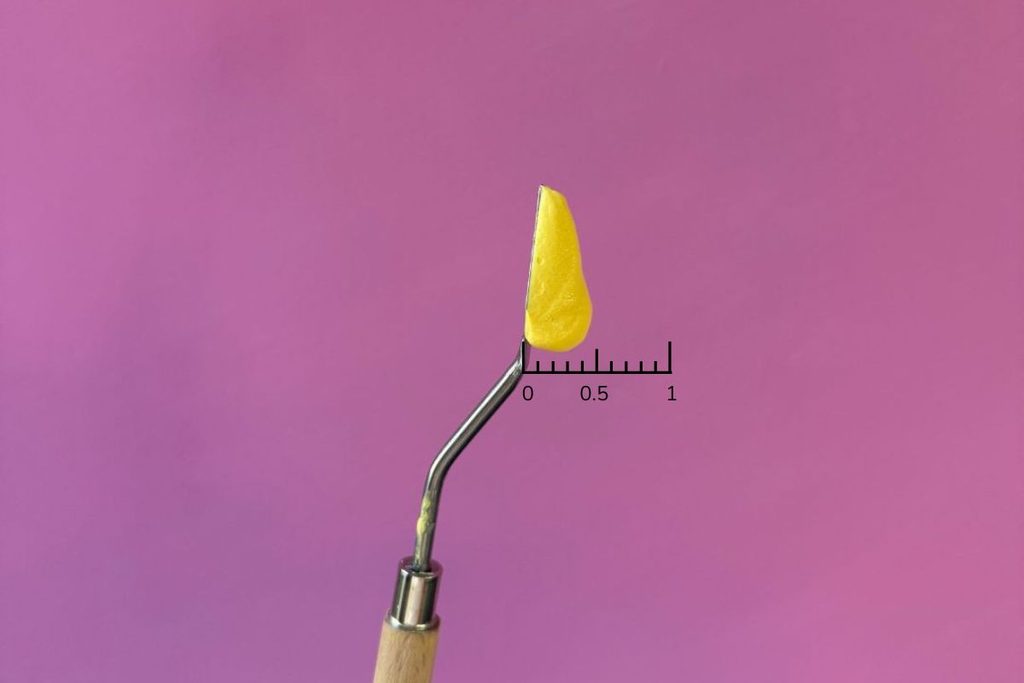 Palette knife loaded with half inch of light modeling paste and ruler showing the depth to load the palette knife