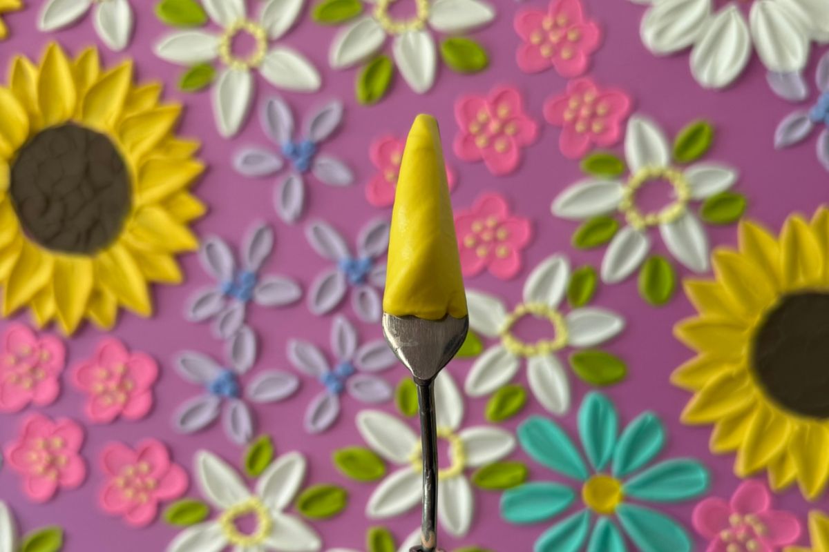 Textured floral art flowers in background with close up of yellow texture on palette knife